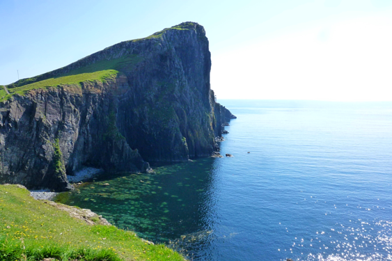 A large body of water with a cliff in the background.