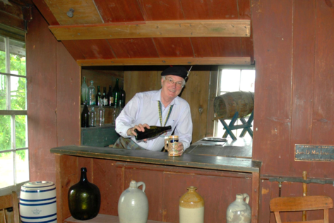 A man standing at the bar of a restaurant.