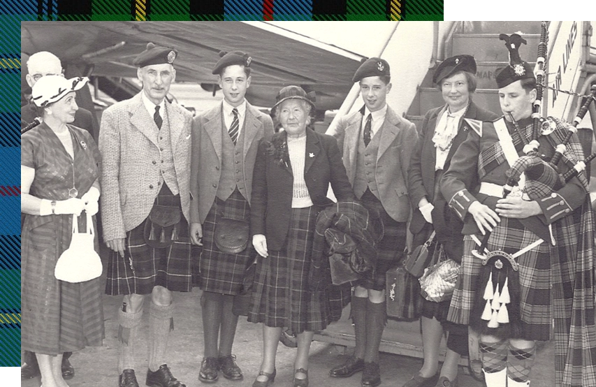 A group of people in scottish garb standing next to each other.